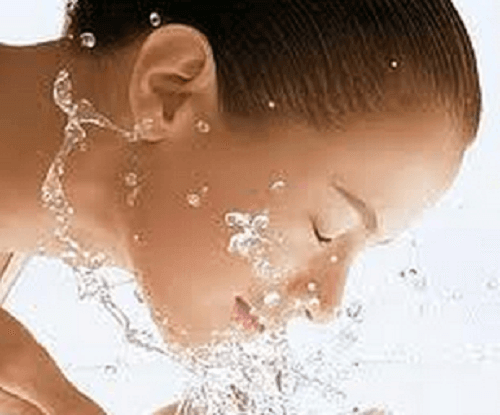 дівчина промиває обличчя водою