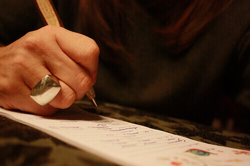 жінка тримає ручку та пише