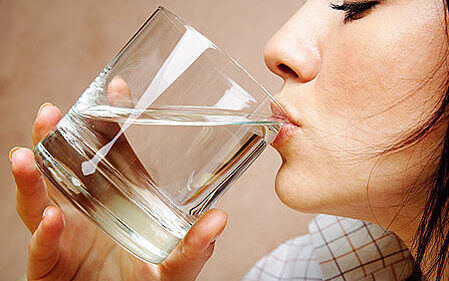 дівчина п'є воду зі склянки