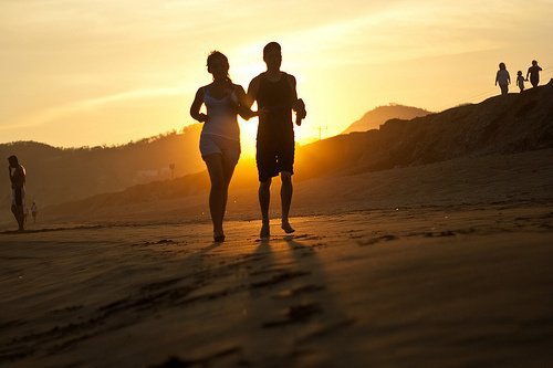 пари біжить на пляжі