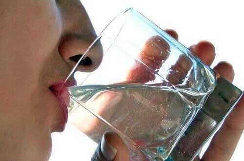 людина п'є воду зі склянки