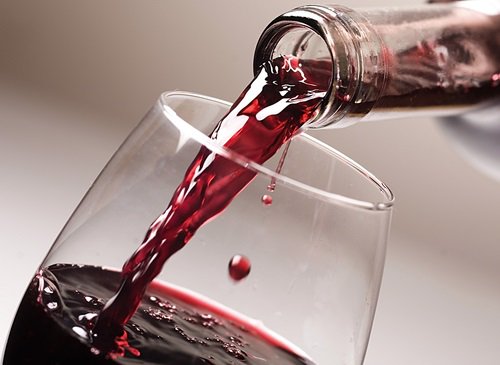червоне вино наливається у келих