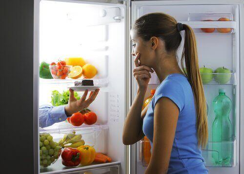 дівчина перед відкритим холодильником