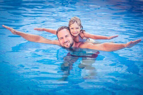 батько вчить дочку плавати