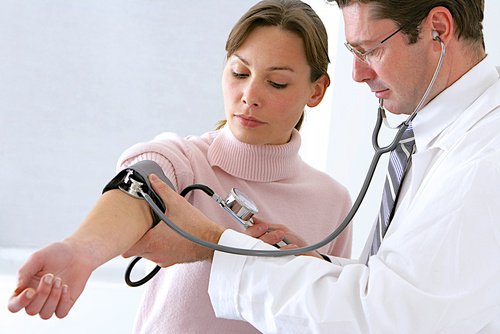 лікар вимірює артеріальний тиск жінці