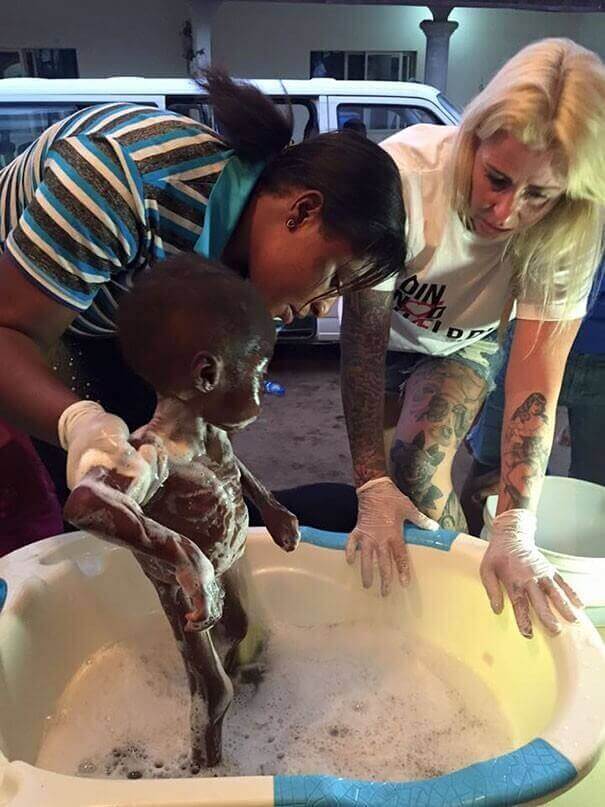 дорослі купають дівчинку