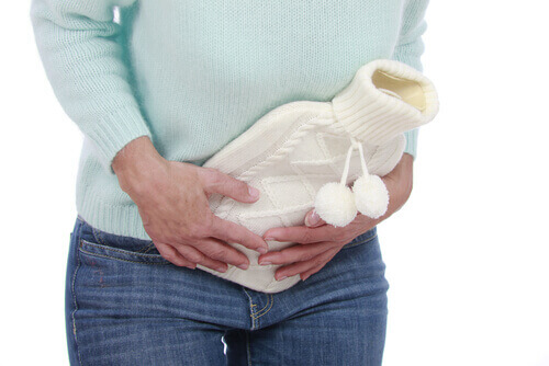 жінка гріє живіт