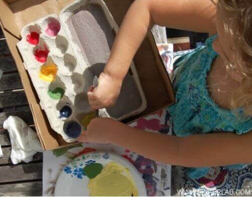 дівчинка змішує фарби за допомогою коробки від яєць