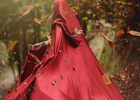 жінка у червоному плащі у лісі