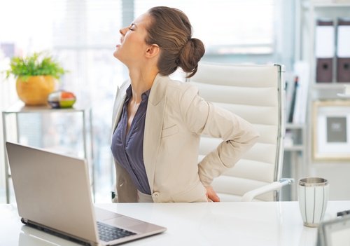 жінка під час роботи за комп'ютером відчуває біль в попереку