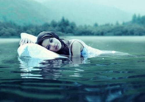 жінка з подушкою у воді