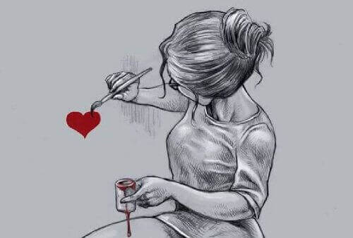 дівчина малює фарбою серце