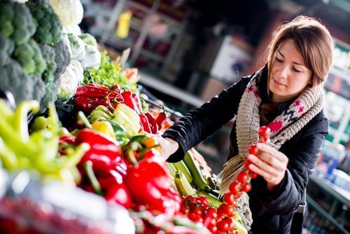 женщина покупает овощи