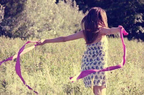 дівчина в полі з рожевою стрічкою