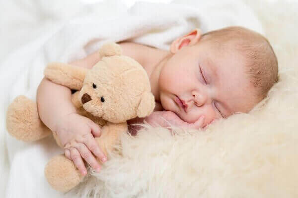малюк спить з іграшкою