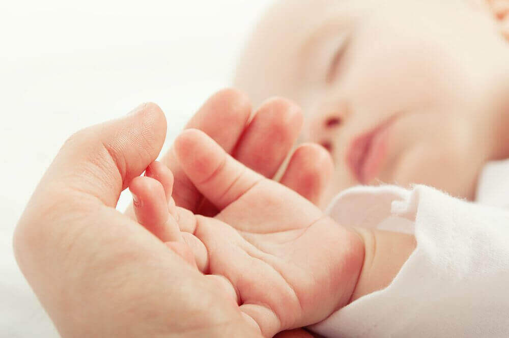 людина тримає малюка за руку