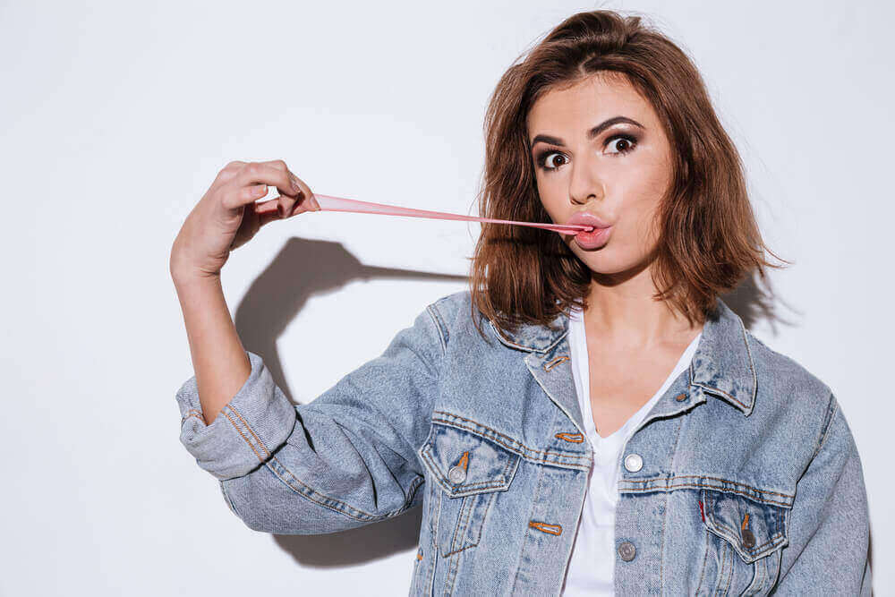 дівчина розтягує жувальну гумку