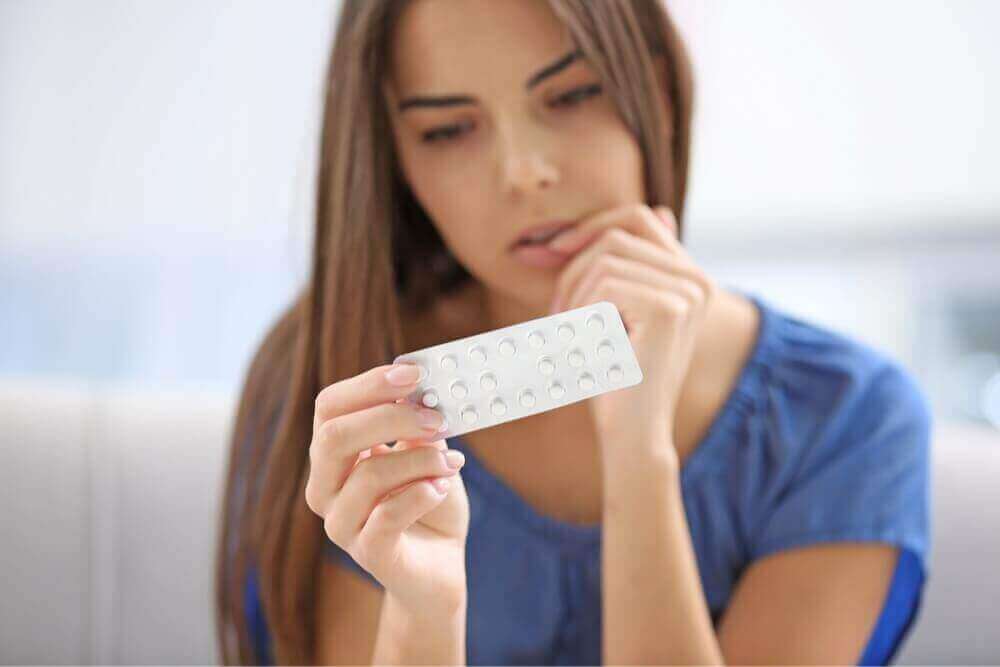 дівчина дивиться на таблетки